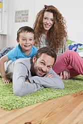 Germany, Berlin, Family lying on floor, smiling, portrait - RBF000963