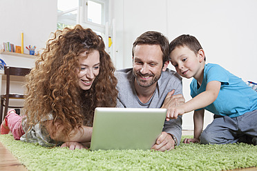 Germany, Berlin, Family using digital tablet on floor - RBF000978