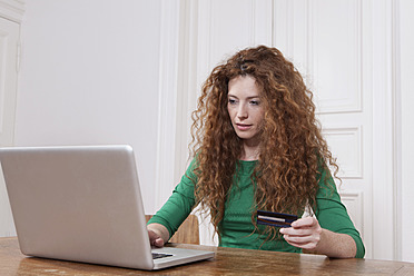 Deutschland, Berlin, Junge Frau benutzt Laptop zum Homeshopping - RBF001001