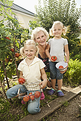 Deutschland, Bayern, Großmutter mit Kindern im Gemüsegarten - RNF001007