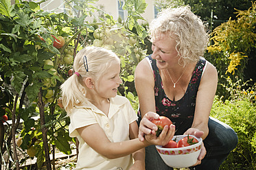 Germany, Bavaria, Grandmother and granddaughter working in vegetable garden - RNF001008