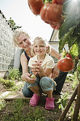 Deutschland, Bayern, Großmutter und Enkelin arbeiten im Gemüsegarten - RNF001009