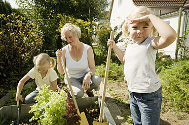 Germany, Bavaria, Grandmother with children working in vegetable garden - RNF001022