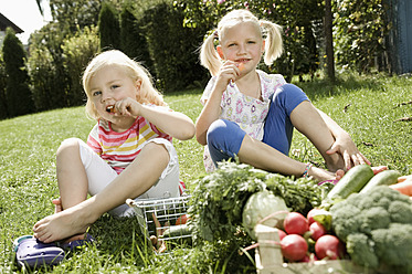 Deutschland, Bayern, Mädchen essen Gemüse im Garten - RNF001043