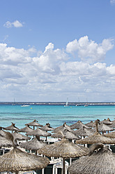 Spain, Mallorca, Straw beach umbrellas at Es Trenc - MAEF004897