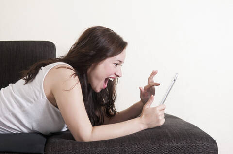 Deutschland, Berlin, Junge Frau mit digitalem Tablet, lächelnd, lizenzfreies Stockfoto