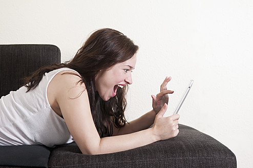 Deutschland, Berlin, Junge Frau mit digitalem Tablet, lächelnd - BFRF000074