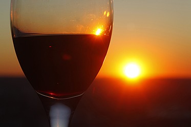 Germany, Close up of wine glass with red wine at sunset - JTF000015