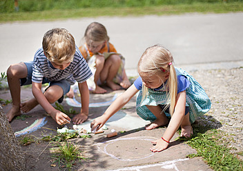 Deutschland, Bayern, Gruppe von Kindern, die mit Kreide auf einem Gehweg zeichnen - HSIYF000018