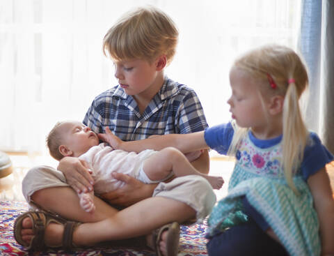 Deutschland, Bayern, Kinder halten kleines Mädchen, lizenzfreies Stockfoto