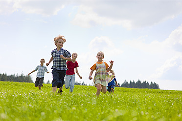 Deutschland, Bayern, Gruppe von Kindern, die über eine Wiese laufen - HSIYF000031