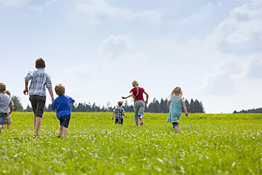 Deutschland, Bayern, Gruppe von Kindern, die über eine Wiese laufen - HSIYF000032