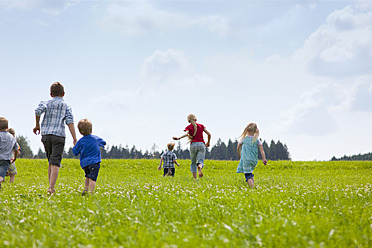 Germany, Bavaria, Group of children running through meadow - HSIYF000032