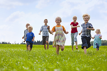 Deutschland, Bayern, Gruppe von Kindern, die über eine Wiese laufen - HSIYF000034
