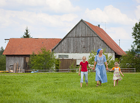 Deutschland, Bayern, Großmutter mit Kindern vor Bauernhaus spazierend - HSIYF000035