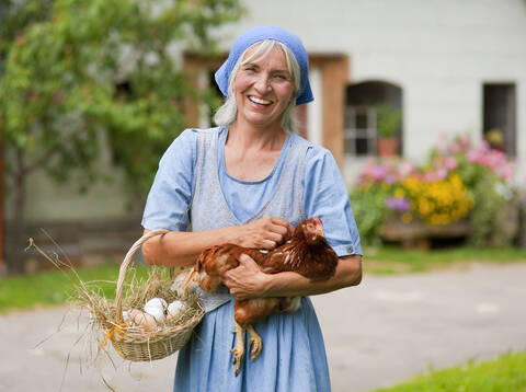 Deutschland, Bayern, Ältere Frau mit Korb mit frischen Eiern und Hühnern, lizenzfreies Stockfoto