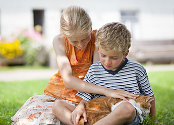 Deutschland, Bayern, Junge und Mädchen mit Katze auf dem Bauernhof - HSIYF000048