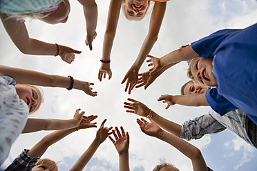 Deutschland, Bayern, Gruppe von Kindern, die die Hände in die Luft heben - HSIYF000052