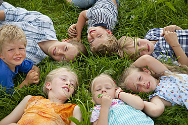 Deutschland, Bayern, Gruppe von Kindern auf einer Wiese liegend - HSIYF000055