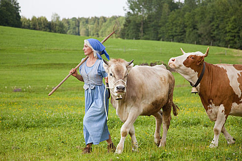 Deutschland, Bayern, Reife Frau mit Kuh auf Bauernhof - HSIYF000066