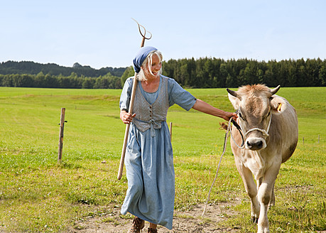 Germany, Bavaria, Mature woman with cow on farm - HSIYF000068