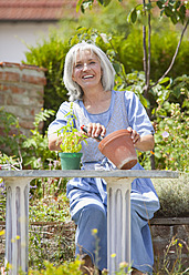 Deutschland, Bayern, Ältere Frau bei der Gartenarbeit, lächelnd - HSIYF000123