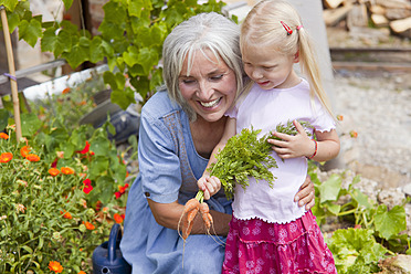 Deutschland, Bayern, Reife Frau mit Mädchen im Garten - HSIYF000130