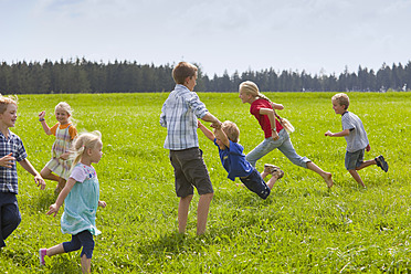 Deutschland, Bayern, Gruppe von Kindern, die auf einer Wiese spielen - HSIYF000137