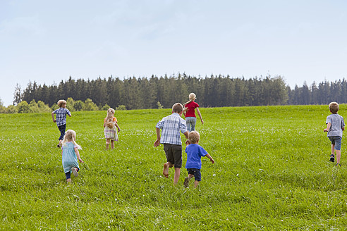 Deutschland, Bayern, Gruppe von Kindern, die über eine Wiese laufen - HSIYF000138