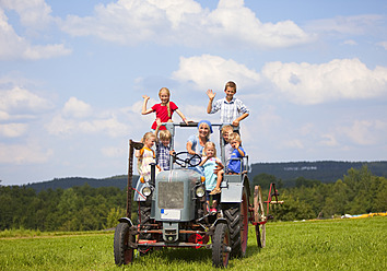 Deutschland, Bayern, Frau mit Kindergruppe in altem Traktor sitzend - HSIYF000143