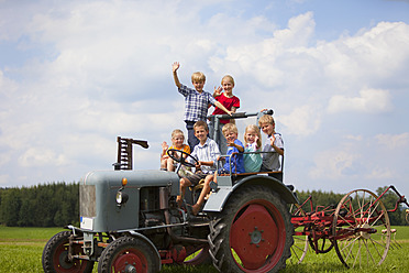 Deutschland, Bayern, Gruppe von Kindern, die in einem alten Traktor sitzen - HSIYF000144