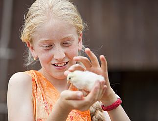 Germany, Bavaria, Girl with baby chick, close up - HSIYF000148