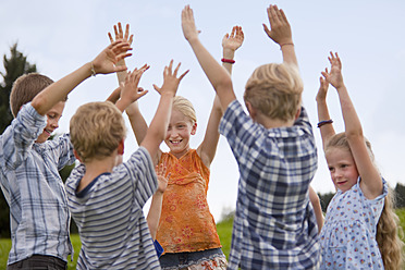 Deutschland, Bayern, Gruppe von Kindern, die die Hände in die Luft heben - HSIYF000151