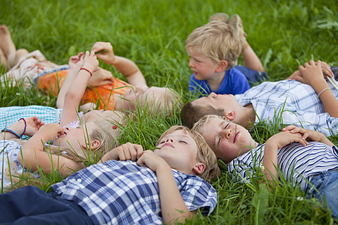 Deutschland, Bayern, Gruppe von Kindern auf einer Wiese liegend - HSIYF000153