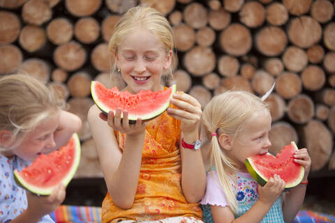 Deutschland, Bayern, Mädchen essen Wassermelone, lizenzfreies Stockfoto