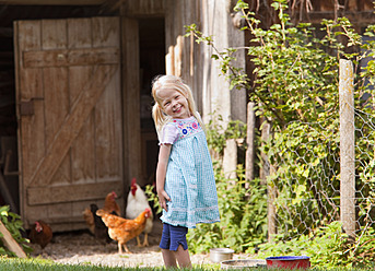 Deutschland, Bayern, Mädchen mit Huhn auf Bauernhof - HSIYF000104