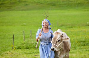 Deutschland, Bayern, Reife Frau mit Kuh auf Bauernhof - HSIYF000103