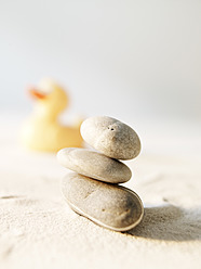 Steine und Gummi-Ente auf Sand stapeln - FMKF000670