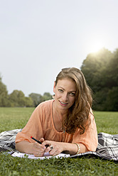 Germany, Berlin, Young student learning in Treptower Park - FKF000068