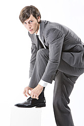 Businessman tying shoes, close up - MAEF004984