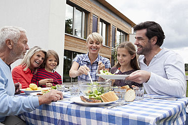 Deutschland, Bayern, Nürnberg, Familie beim Grillen im Garten - RBYF000220