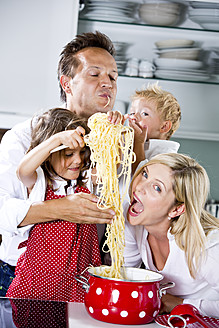 Deutschland, Familie spielt mit Spaghetti auf der Küchenarbeitsplatte - RFF000058