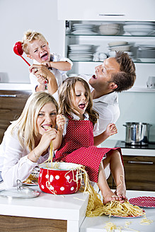 Deutschland, Familie spielt mit Spaghetti auf der Küchenarbeitsplatte - RFF000064