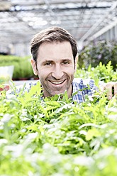 Germany, Bavaria, Munich, Mature man in greenhouse with rocket plants - RREF000011