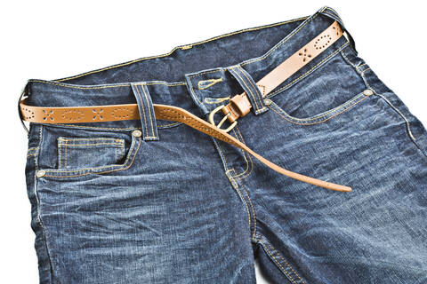 Blue jeans with leather belt on white background stock photo