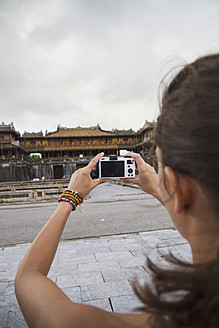 Vietnam, Hue, Junge Frau beim Fotografieren der Zitadelle von Hue - MBEF000522