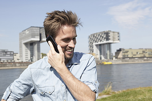 Germany, Cologne, Mid adult man talking on cell phone - RHYF000204