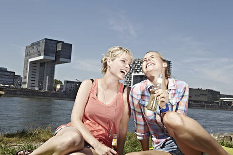 Deutschland, Köln, Junge Frauen trinken Bier, lizenzfreies Stockfoto