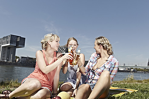 Germany, Cologne, Young women drinking beer - RHYF000263