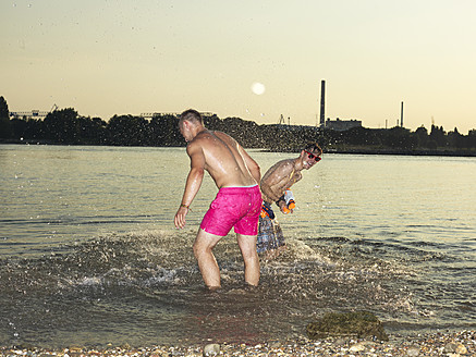 Germany, Duesseldorf, Young friends playing in water - STKF000041